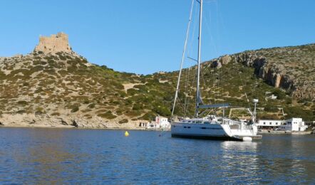 Segelyacht Bavaria cruiser 45 „Eva" vor Anker in der Bucht von Cabrera mit Burg und Hafen im Hintergrund – Yachtcharter