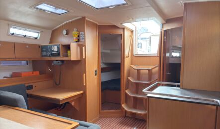 Salon der Segelyacht Bavaria cruiser 45 „Eva" mit Navigationsplatz und Blick in eine Kabine mit Koje – Yachtcharter Mallorca