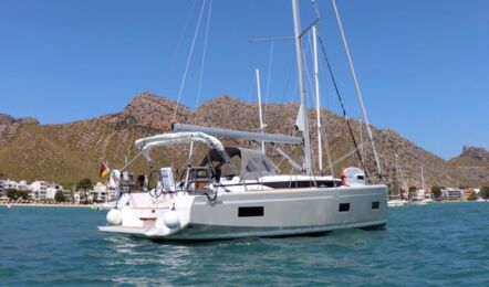 Achterliche Ansicht der Segelyacht Bavaria C38 „Levante" vor Anker in einer Bucht mit Bergkulisse – Yachtcharter Mallorca