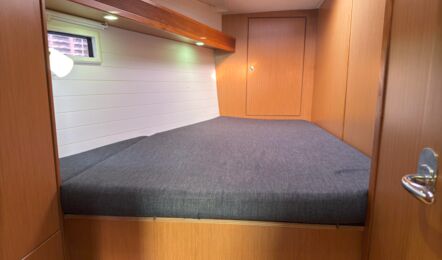 Doppelkabine der Segelyacht Bavaria cruiser 45 „Eva" mit breiter Koje, Holzoptik und Rumpffenster – Yachtcharter Mallorca