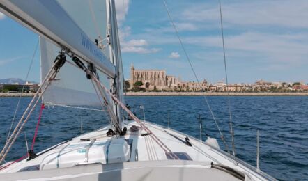 Blick über das Vordeck der segelnden Bavaria cruiser 45 „Eva" auf die Kathedrale von Palma – Yachtcharter Mallorca