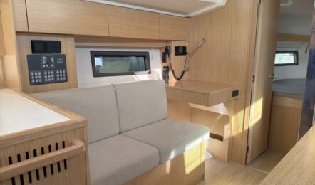 Sitzgruppe im Salon der Segelyacht Bavaria C38 „Levante" mit Schalttafel, Blick zur Achterkabine – Yachtcharter Mallorca