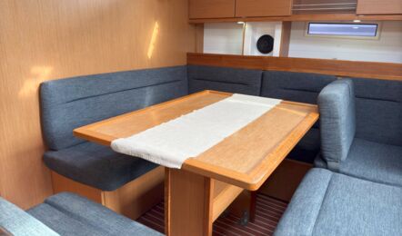 U-Sitzgruppe im Salon der Segelyacht Bavaria cruiser 45 „Eva" mit Esstisch und heller Holzoptik – Yachtcharter Mallorca