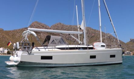 Seitenansicht der Segelyacht Bavaria C38 „Levante" mit grauem Rumpf und Bimini vor Anker in einer Bucht – Yachtcharter Mallorca