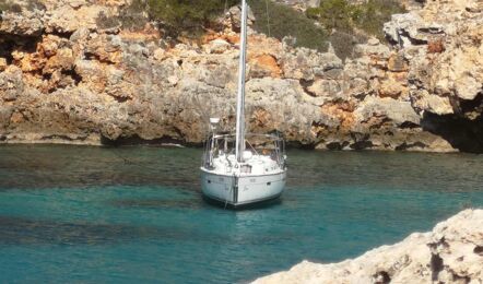 Bugansicht der Segelyacht Bavaria cruiser 45 „Eva" vor Anker in einer türkisfarbenen Felsbucht – Yachtcharter Mallorca